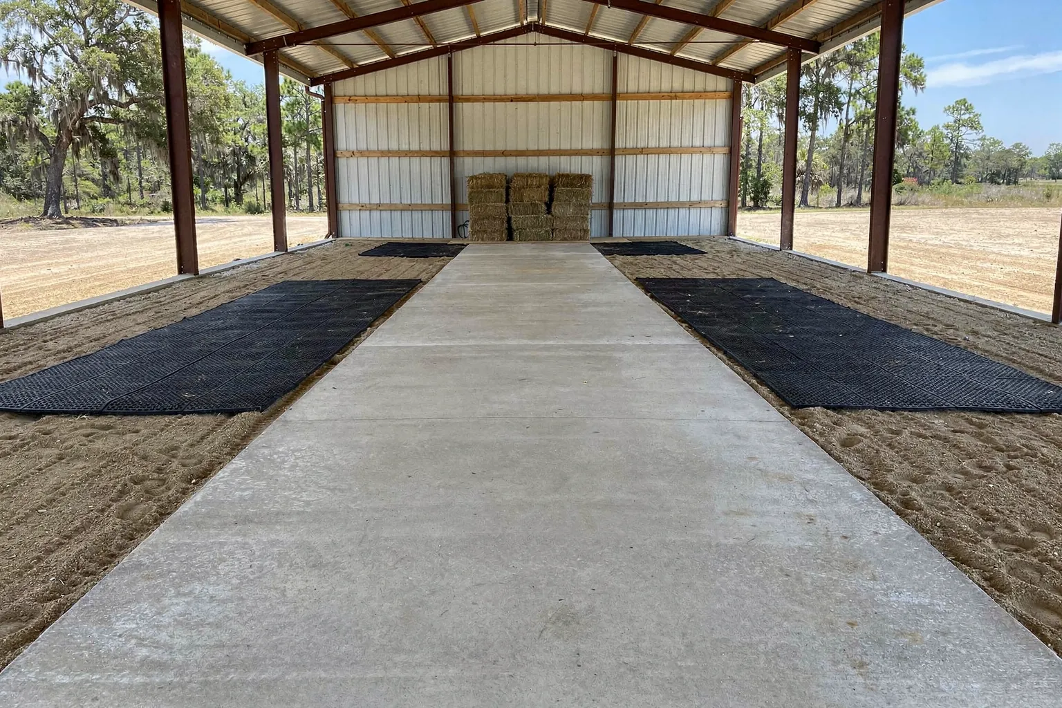 Pole barn with a concrete center aisle and sand stalls on a farm in Polk County